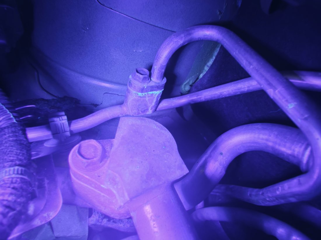Traces de traceur fluorescent à l'UV sur une durite de climatisation