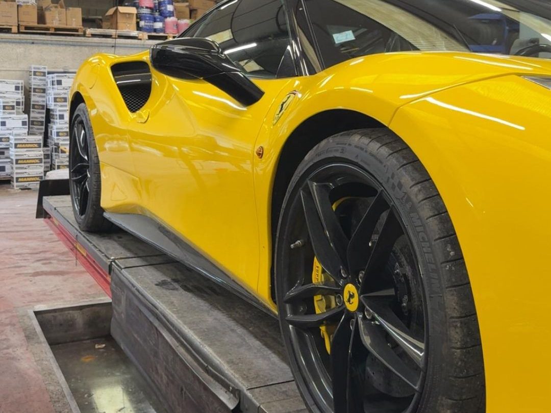 Ferrari 488 installée sur le banc de géométrie de l'atelier Formula Pneus Point S à Sens, vue d'ensemble