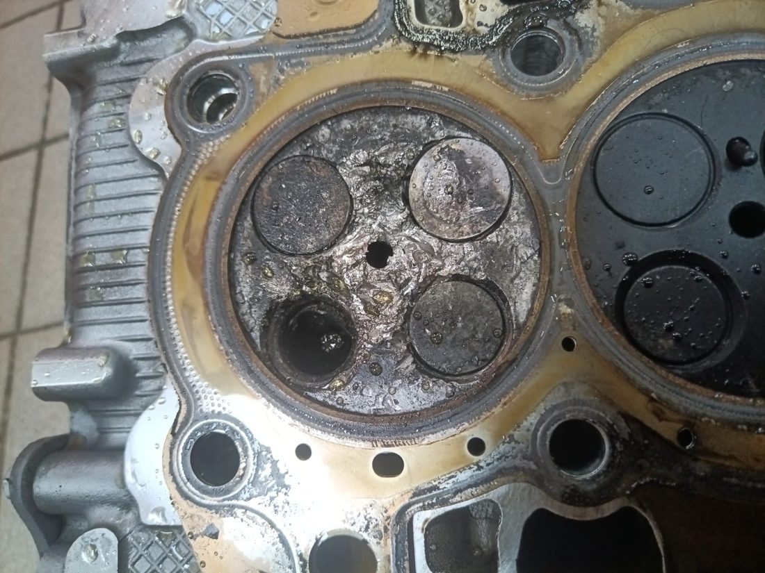Culasse de 1.5 BlueHDi déposée : chambre de combustion détruite, aluminium arraché autour des sièges de soupapes après la casse de la chaîne d'arbres à cames