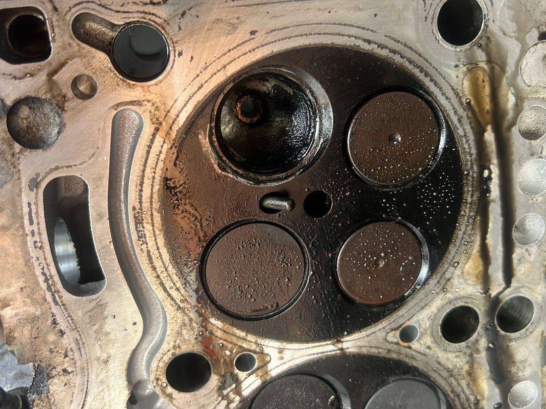 Chambre de combustion d'un Porsche Macan 3.0 diesel vue culasse déposée : soupapes, sièges et dépôts de combustion