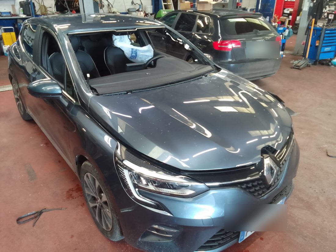 Renault Clio dans l'atelier Formula Pneus Point S à Sens, pare-brise déposé avant remplacement du vitrage