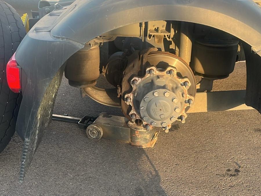 Porteur levé au cric, roue déposée : moyeu, disque et suspension pneumatique accessibles